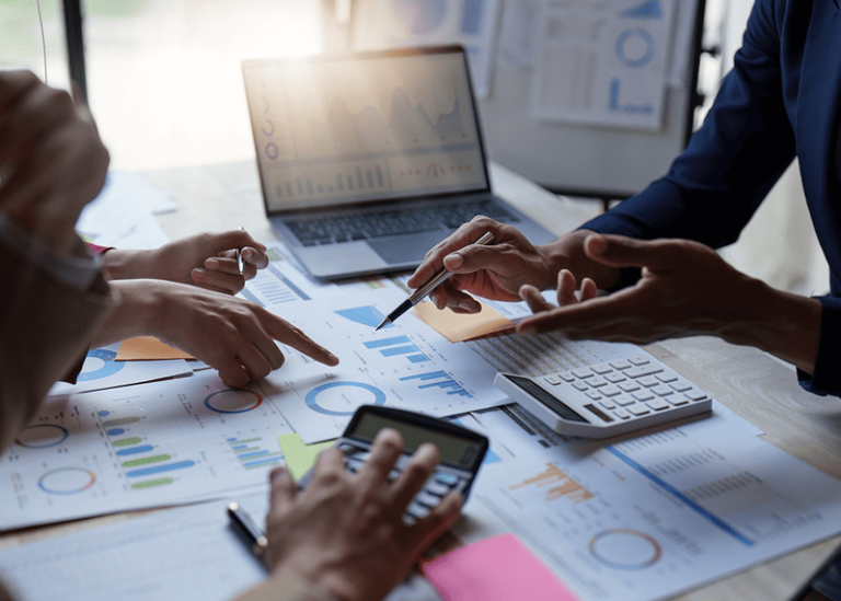 Financial professionals reviewing charts and data for investment or retirement planning strategy.