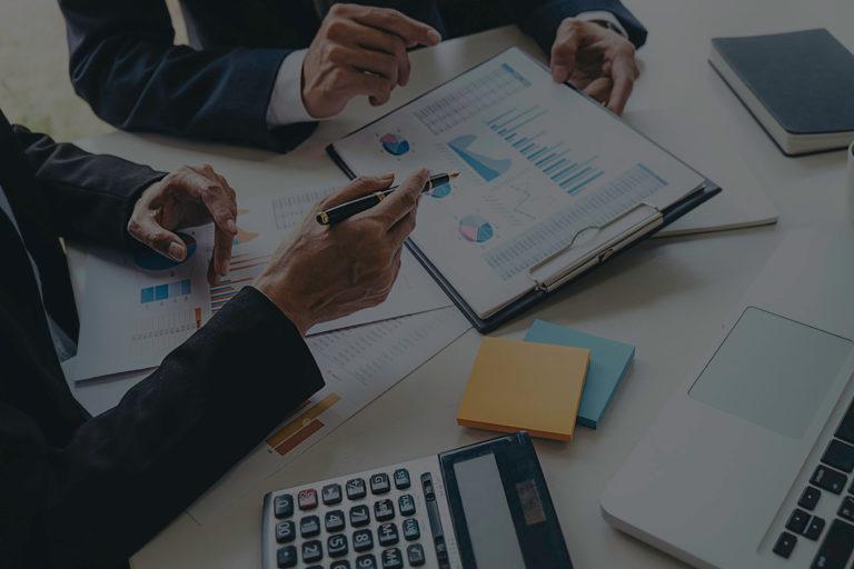 Financial professionals reviewing charts and data for investment or retirement planning strategy.